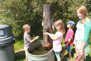 All kids like to play with water pumps! Xavier, Cake, and Nay. Tristan is hidden and is operating the pump.